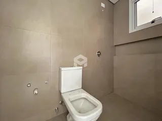 Foto de um banheiro com paredes revestidas de cerâmica e um vaso sanitário branco.