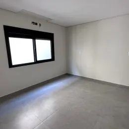 Foto de um cômodo interno com paredes brancas e uma janela.