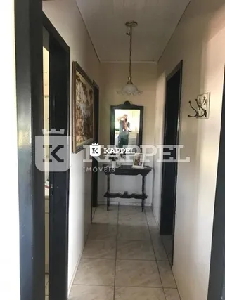 Foto de um corredor interno com piso de cerâmica e portas escuras.