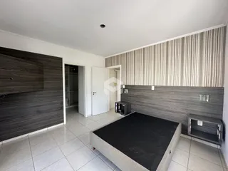 Ambiente interno com revestimento de madeira nas paredes e piso cerâmico.