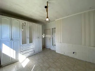 Interior de um cômodo com armários brancos e piso de cerâmica.