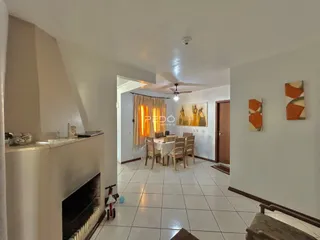 Interior de uma sala de estar com lareira e piso de cerâmica.