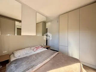 Quarto com armários embutidos e cama grande.