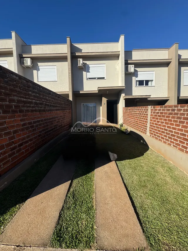 Fachada de um imóvel residencial em Lajeado, Brasil, mostrando a parede de tijolos e o paisagismo frontal.