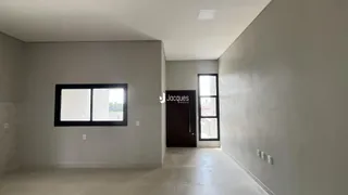 Corredor interno de uma residência com paredes brancas e piso claro.