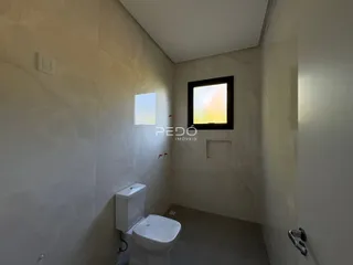 Corredor interno de um imóvel em Lajeado, Brasil, com um vaso sanitário e janela.