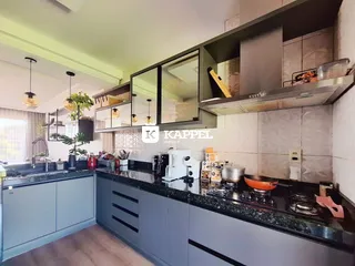 Cozinha moderna com armários escuros e bancadas escuras.