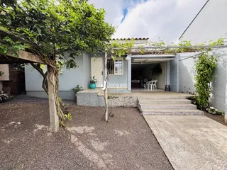 Fachada de uma residência em Lajeado, Brasil, com vegetação exuberante na frente.