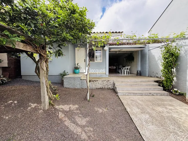 Fachada de uma residência em Lajeado, Brasil, com vegetação exuberante na frente.