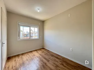 Foto de um cômodo interno com piso de madeira clara e paredes neutras.