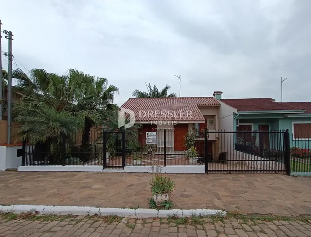 Fachada de uma casa em Lajeado, Brasil, com muro e portão de ferro.