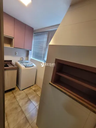 Vista interna de uma cozinha com armários e piso de cerâmica.