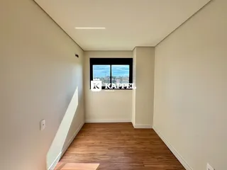 Hall de corredor com piso de madeira e janela.