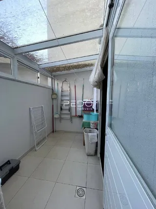 Vista interna de um corredor com moldura de vidro em uma propriedade.