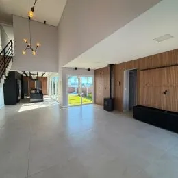Ambiente amplo com piso claro e detalhes em madeira na sala de estar.