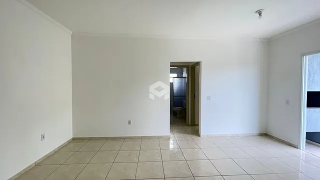 Vista interna de um ambiente com piso de cerâmica e paredes brancas.