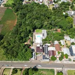 Vista aérea de uma propriedade com vegetação densa ao redor.