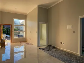 Uma sala ampla com piso de porcelanato polido e janela.