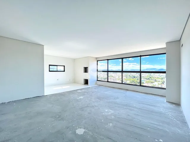 Interior de um espaço vazio com grande janela de vista para a paisagem.