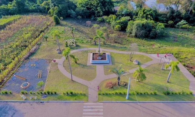 Área externa gramada com árvores e caminho de terra.