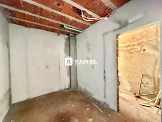 Foto de um cômodo interno com paredes e teto em fase de acabamento.