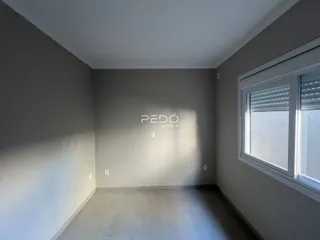 Foto de uma sala interna com paredes cinzas e uma janela.