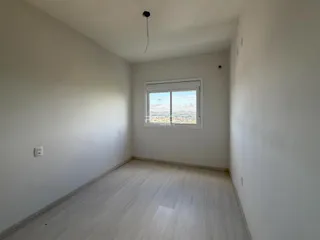 Ambiente interno com piso de madeira clara e janela com vista.