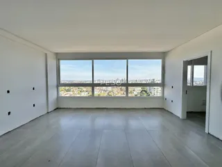 Uma sala ampla com grande janela de vista para a cidade.