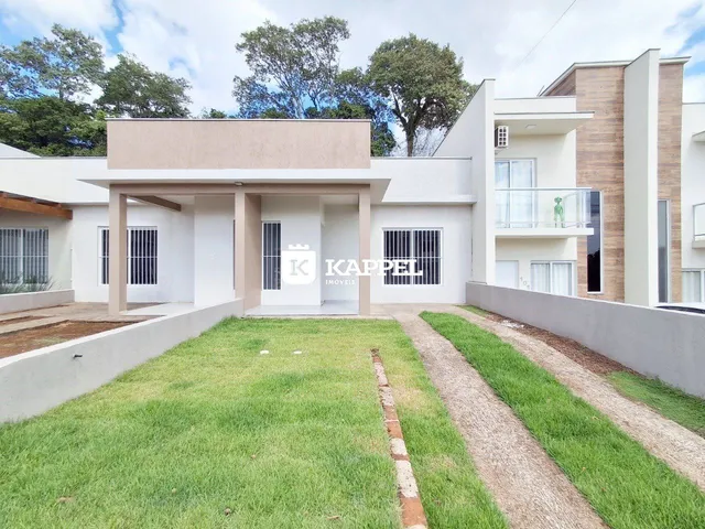 Fachada de uma casa moderna em Lajeado, Brasil, com jardim frontal e caminho de acesso.