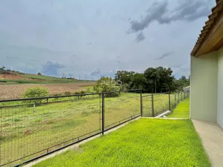 Vista externa de um terreno com cerca e campo verde no Brasil.