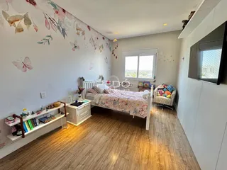 Quarto com decoração floral e piso de madeira clara.