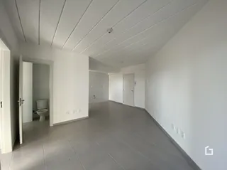 Corredor interno com paredes brancas e piso claro.
