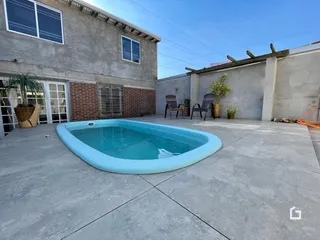 Foto da área externa com piscina e parede de concreto de uma residência em Lajeado.