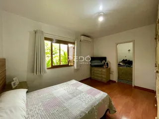 Quarto com janela e piso de madeira.