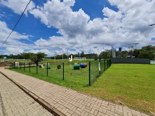 Vista externa de um jardim com cerca e calçada.
