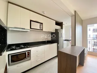 Cozinha moderna com armários brancos e bancada escura.