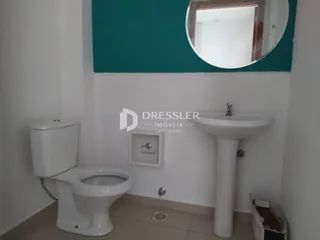 Foto de um banheiro interno com vaso sanitário e pia brancos.