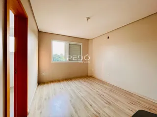 Sala de estar com piso de madeira clara e janela.