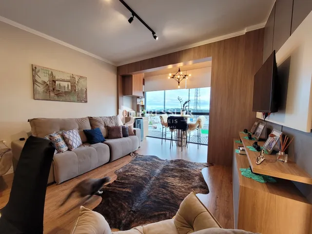 Sala de estar com sofá e piso de madeira em um imóvel no Brasil.