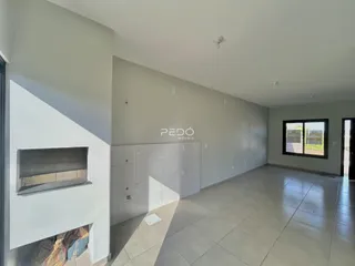 Sala de estar com piso de cerâmica e paredes cinzas em um imóvel no Brasil.