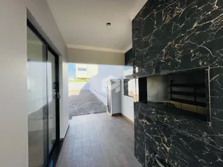 Hall de entrada com piso de cerâmica e parede de mármore preta.