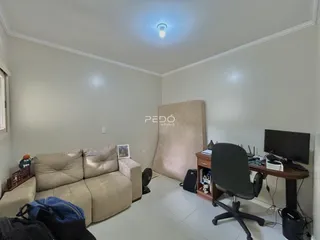 Sala de estar com sofá e área de trabalho em um imóvel.
