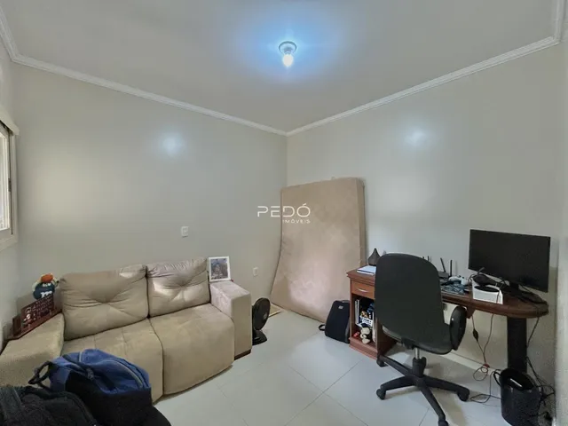 Sala de estar com sofá e área de trabalho em um imóvel.