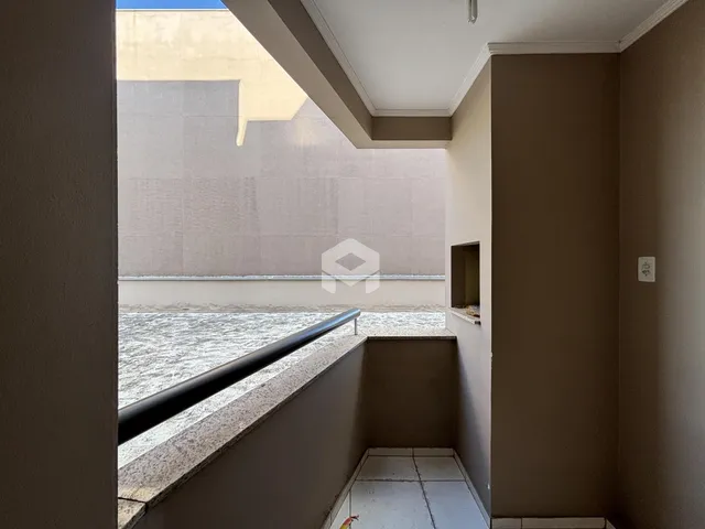 Vista de um corredor com parapeito de pedra que se abre para uma área externa.