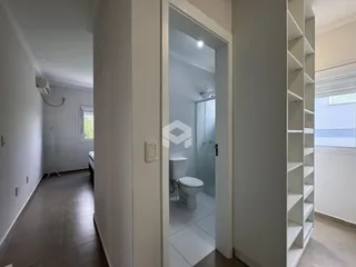 Vista de um corredor interno com acesso a um banheiro em um imóvel no Brasil.