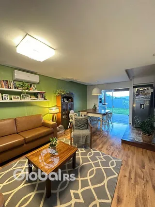 Sala de estar com sofá e piso de madeira em uma residência.