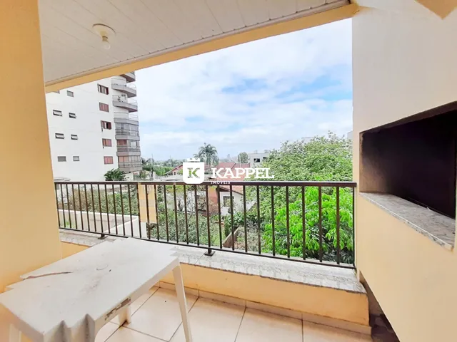 Vista da varanda mostrando vegetação e edifícios ao fundo.