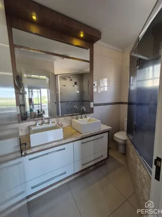 Esta é uma cozinha com armários brancos e bancada clara.