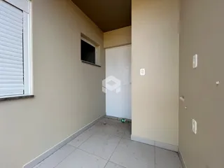 Corredor interno com piso de cerâmica e paredes claras.