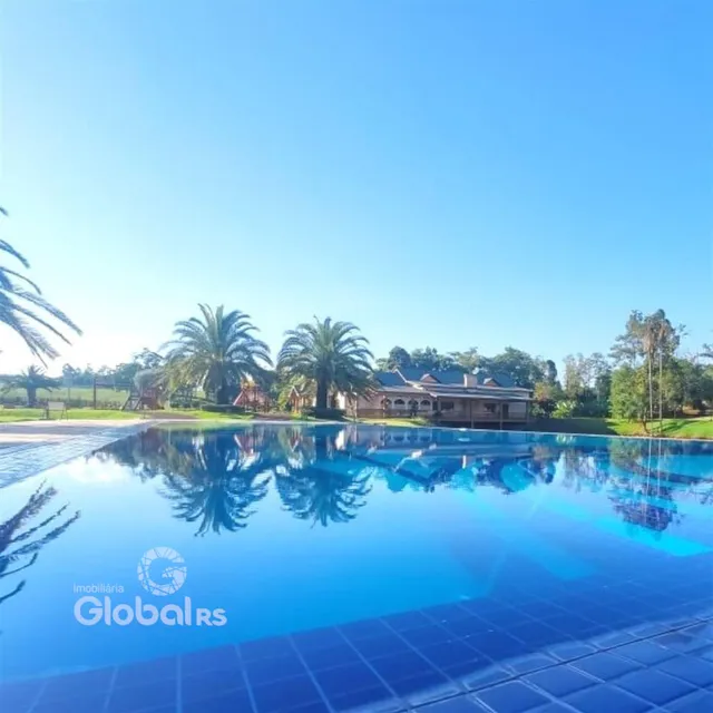Foto da piscina externa refletindo o céu e a vegetação ao fundo da propriedade.